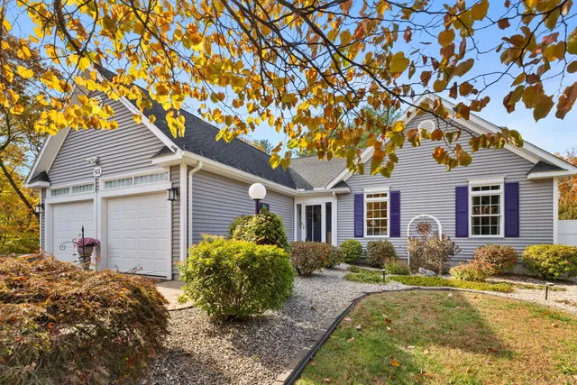 a front view of house with yard and trees around