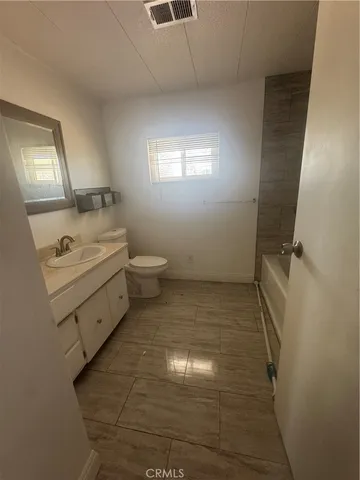 a bathroom with a sink a toilet and mirror