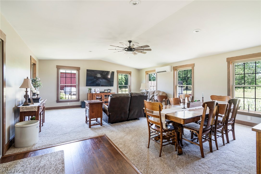 11711 Bandy Road Alliance, OH 44601 - Photo 31 of 50 Carpeted dining room with vaulted ceiling, a wall mounted air conditioner, a wealth of natural light, and ceiling fan