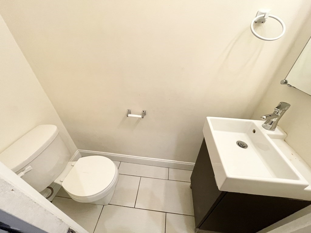 98 L Street, Unit STREET Boston, MA 02127 - Photo 15 of 19 a bathroom with a sink a toilet and a mirror