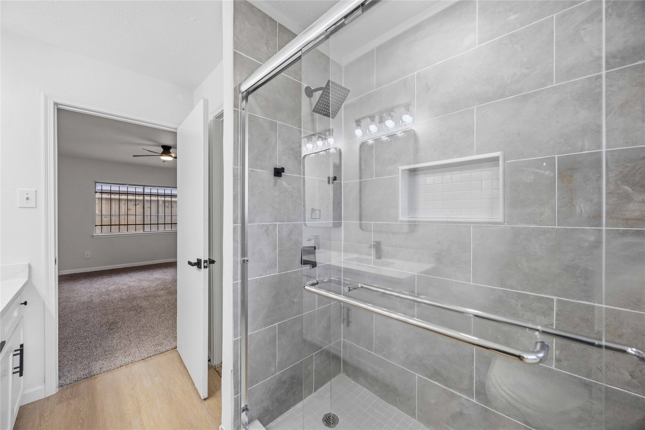 12703 Redfern Drive Houston, TX 77048 - Photo 17 of 28 Beautifully tiled walk-in shower with glass enclosure and built-in niche—combining modern design with everyday convenience.