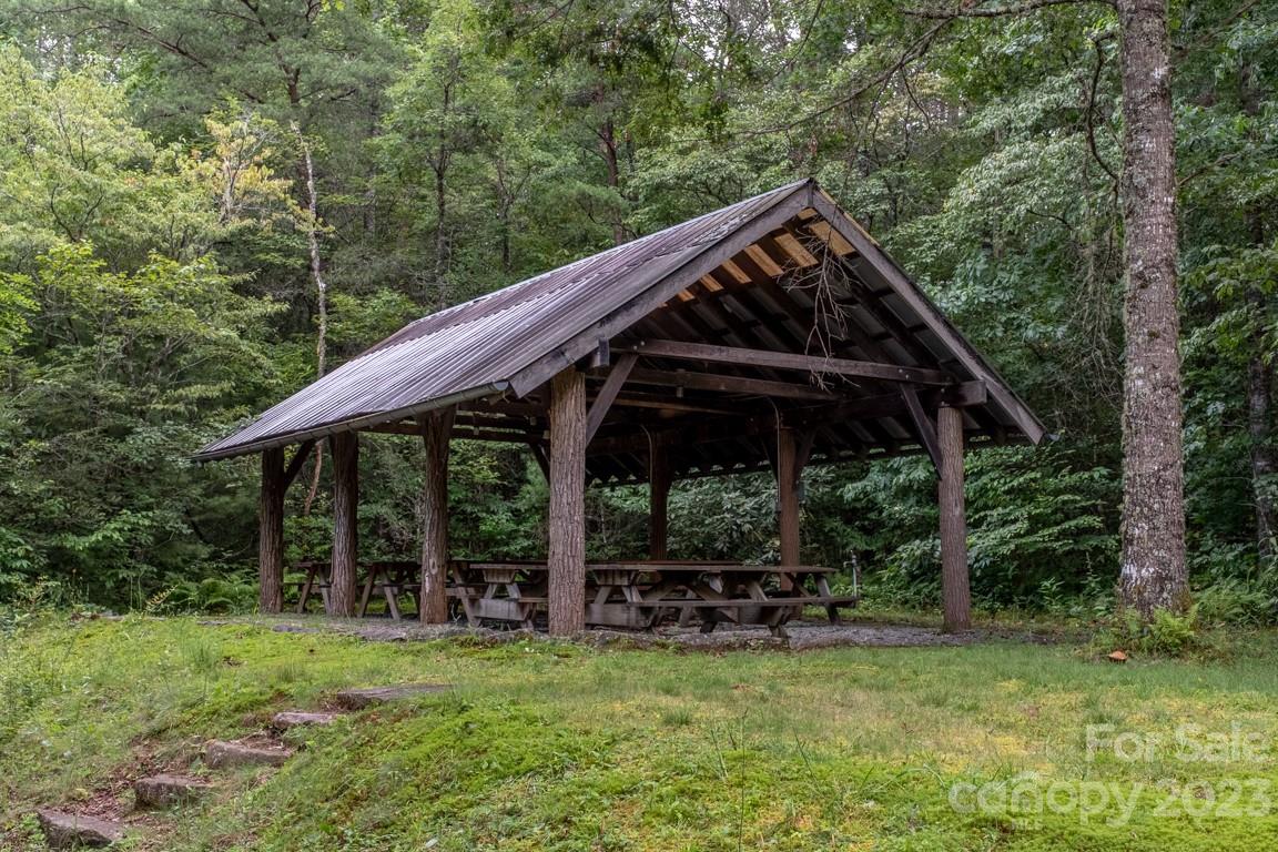 427 Quarry Road, Unit 22 Lake Toxaway, NC 28747 - Photo 16 of 21 a view of backyard with table and chairs under an umbrella with large trees