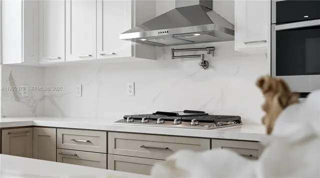 a kitchen with a stove and white cabinets