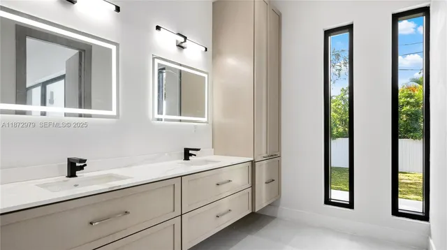 a bathroom with a double vanity sink and a window