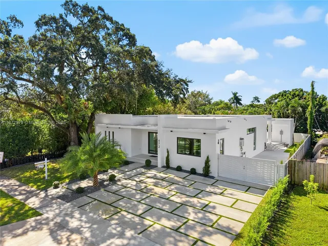 a view of a house with backyard and sitting area