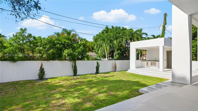a view of a house with a yard and potted plants