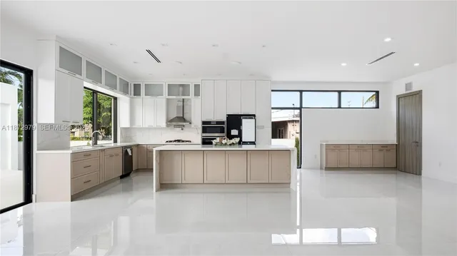 a large white kitchen with cabinets