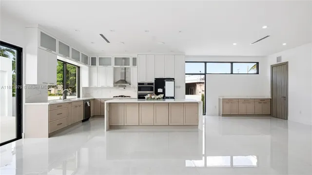 a large white kitchen with cabinets