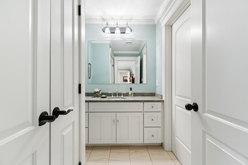 27 Whitehall Circle Beverly, MA 01915 - Photo 28 of 42 a bathroom with a granite countertop sink a mirror and a vanity