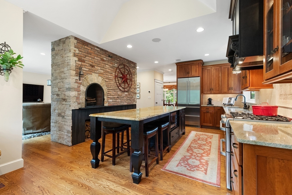 27 Whitehall Circle Beverly, MA 01915 - Photo 7 of 42 a open kitchen with stainless steel appliances granite countertop a stove a sink dishwasher and a fireplace with wooden floor