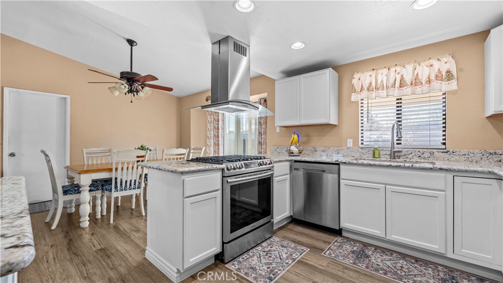 11639 Pagosi Road Apple Valley, CA 92308 - Photo 15 of 37 a kitchen with stainless steel appliances granite countertop a stove a sink and a refrigerator