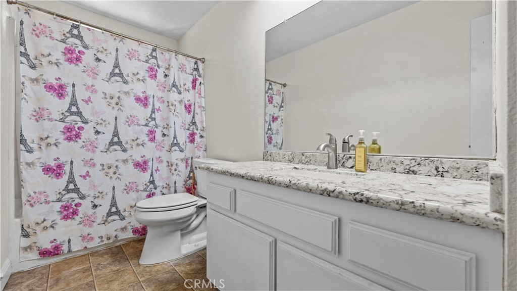 11639 Pagosi Road Apple Valley, CA 92308 - Photo 21 of 37 a bathroom with a granite countertop sink mirror vanity and toilet