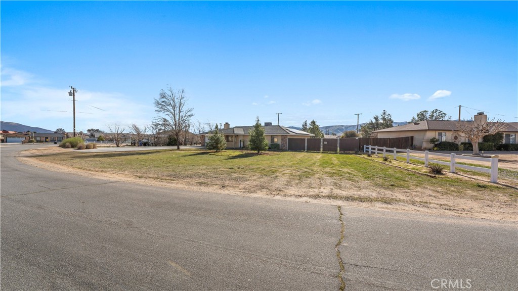 11639 Pagosi Road Apple Valley, CA 92308 - Photo 4 of 37 a view of a house with a big yard and palm trees