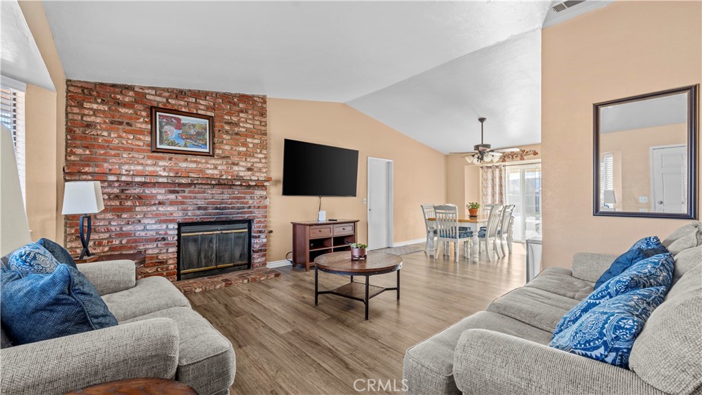 11639 Pagosi Road Apple Valley, CA 92308 - Photo 5 of 37 a living room with furniture a fireplace and a flat screen tv
