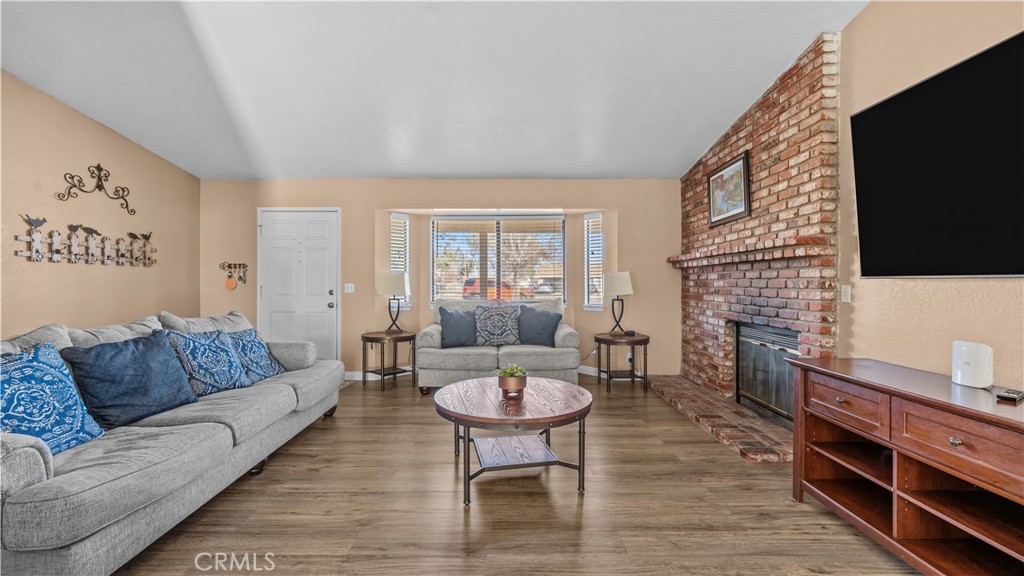 11639 Pagosi Road Apple Valley, CA 92308 - Photo 7 of 37 a living room with furniture a flat screen tv and a fireplace