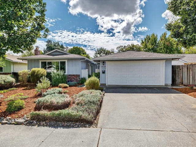 a front view of house with yard and trees around