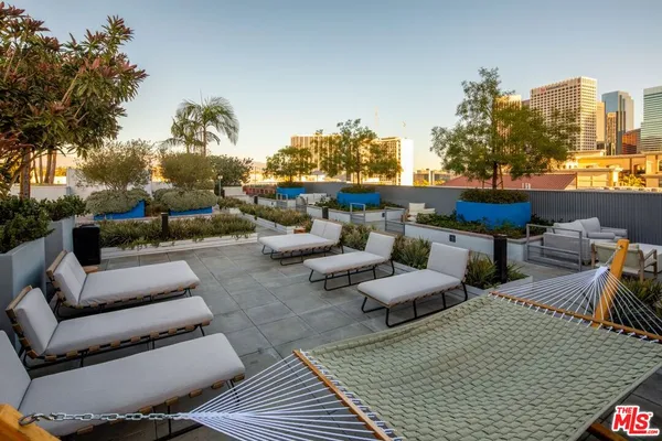 a view of a patio with couches table and chairs and potted plants