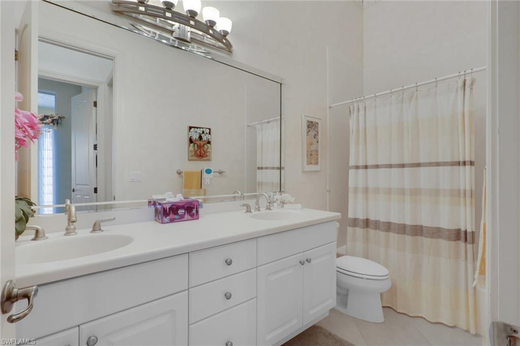 435 Terracina Way Naples, FL 34119 - Photo 21 of 50 Bathroom featuring double vanity, shower / bath combo, and light tile patterned floors