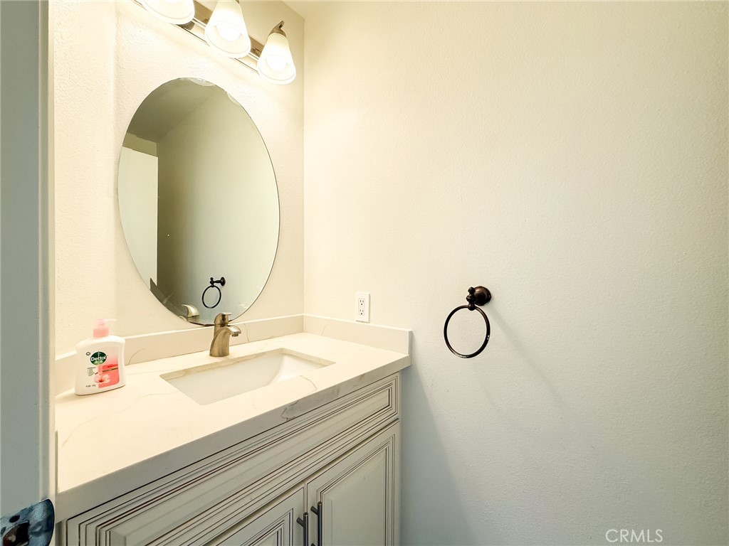 33 Wildflower Place Phillips Ranch, CA 91766 - Photo 25 of 49 a bathroom with a granite countertop sink and a mirror