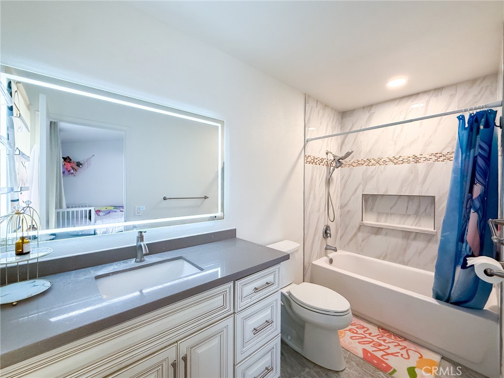 33 Wildflower Place Phillips Ranch, CA 91766 - Photo 28 of 49 a bathroom with a sink a toilet and a large mirror