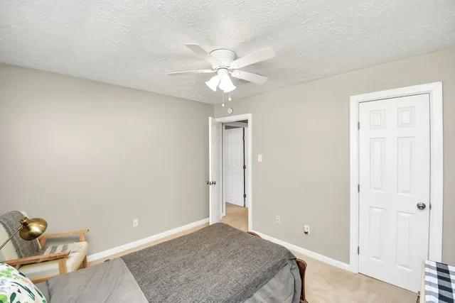 an empty room with closet and a chandelier fan
