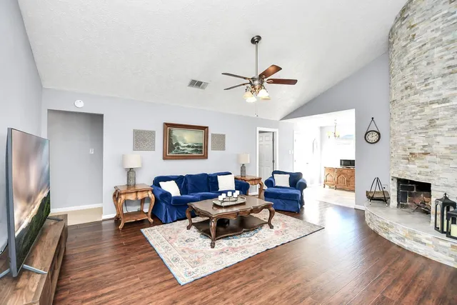 a living room with furniture a fireplace and a flat screen tv