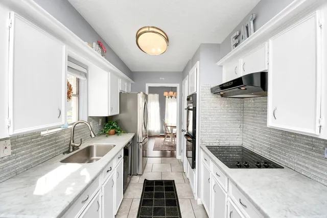 a kitchen with a sink and a stove top oven