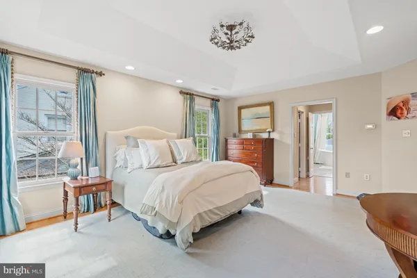 a spacious bedroom with a bed and glass window