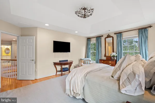 a bedroom with a bed and large windows