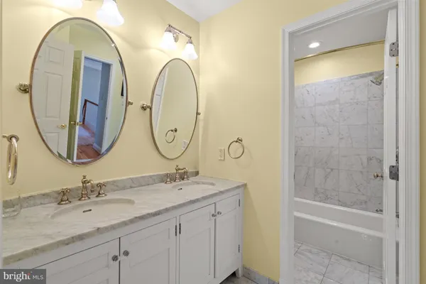 a bathroom with a granite countertop sink a mirror and a shower