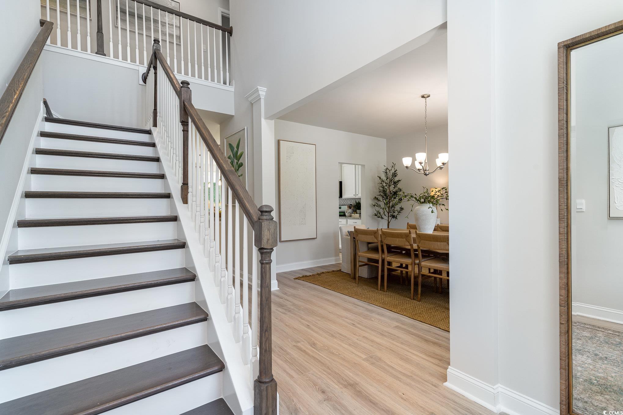 534 Haven View Way Murrells Inlet, SC 29576 - Photo 2 of 32 Staircase featuring a towering ceiling, an inviting chandelier, baseboards, and wood finished floors