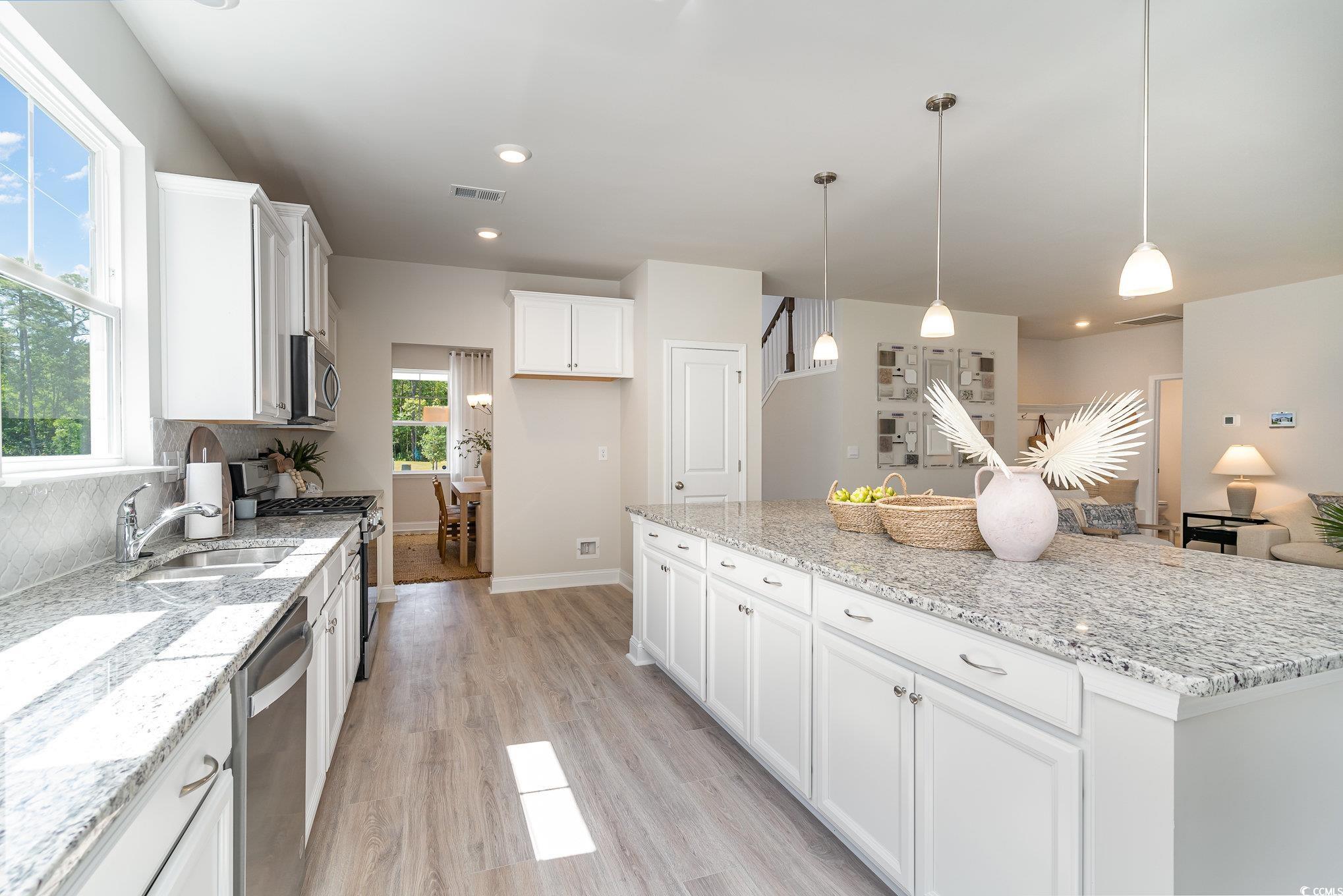 534 Haven View Way Murrells Inlet, SC 29576 - Photo 6 of 32 Kitchen featuring visible vents, a center island, light wood-type flooring, appliances with stainless steel finishes, and white cabinets