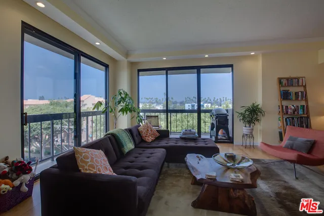 a living room with furniture tv and a floor to ceiling window