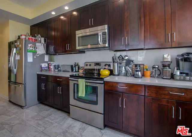 a kitchen with stainless steel appliances granite countertop a refrigerator and a stove top oven