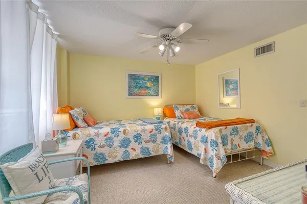 a bedroom with two beds and painting on the wall