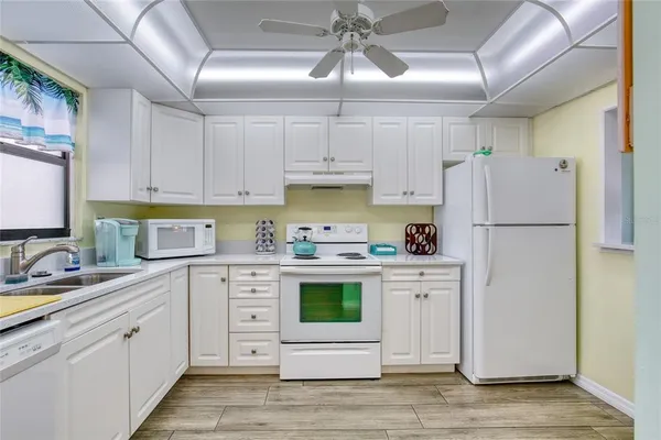 a kitchen with a white cabinets and white appliances