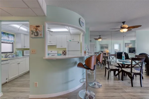 a room with lots of white furniture and wooden floor