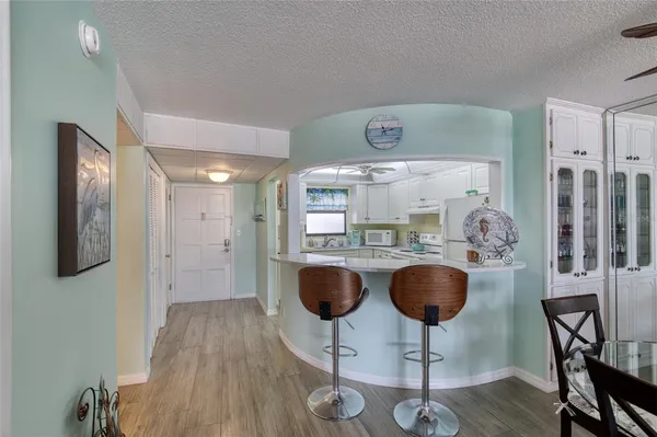 a kitchen with stainless steel appliances granite countertop a table chairs stove and cabinets