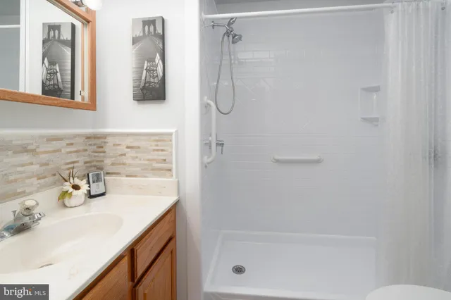 a bathroom with a granite countertop sink a shower and a bathtub