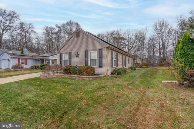 a view of a house with a big yard plants and large trees