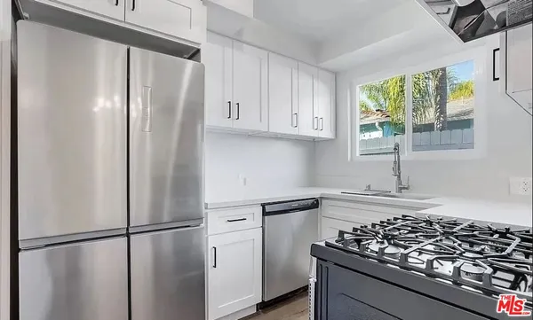 a kitchen with stainless steel appliances granite countertop a refrigerator and a sink