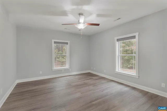 a view of a kitchen with stainless steel appliances refrigerator stove and wooden floor
