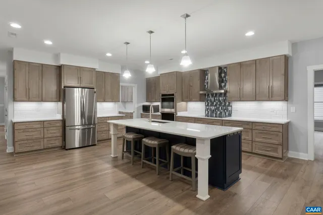 a kitchen with a stove a refrigerator a sink dishwasher with a dining table and chairs