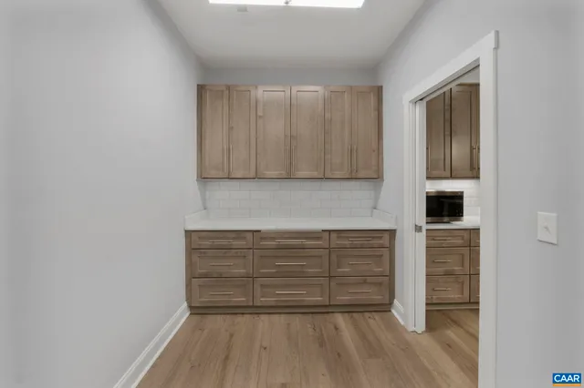 an empty room with wooden floor ceiling fan and windows
