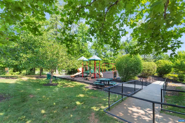 a view of a white house with a big yard and potted plants