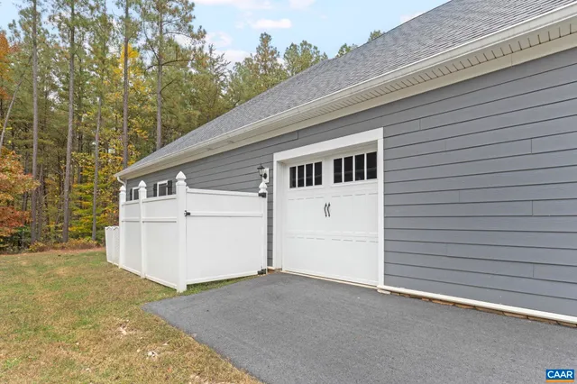 a view of house with a yard and large trees