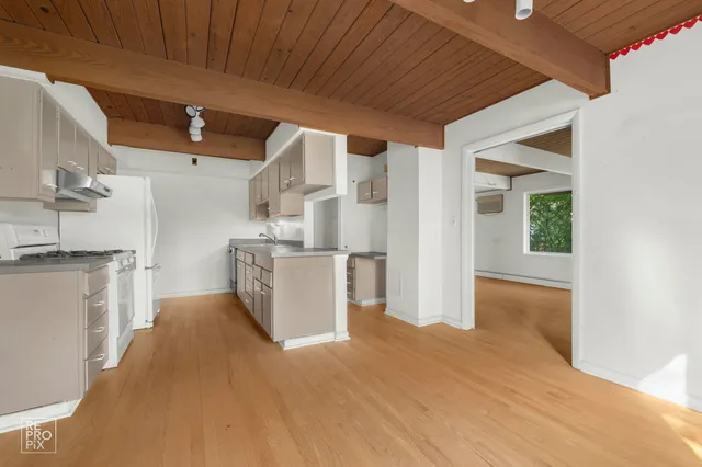 a view of a kitchen with furniture and wooden floor