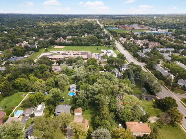 an aerial view of residential houses with outdoor space and trees