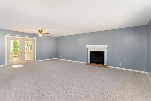 a view of an empty room with a fireplace and a window
