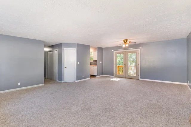 a view of an empty room with window and stairs